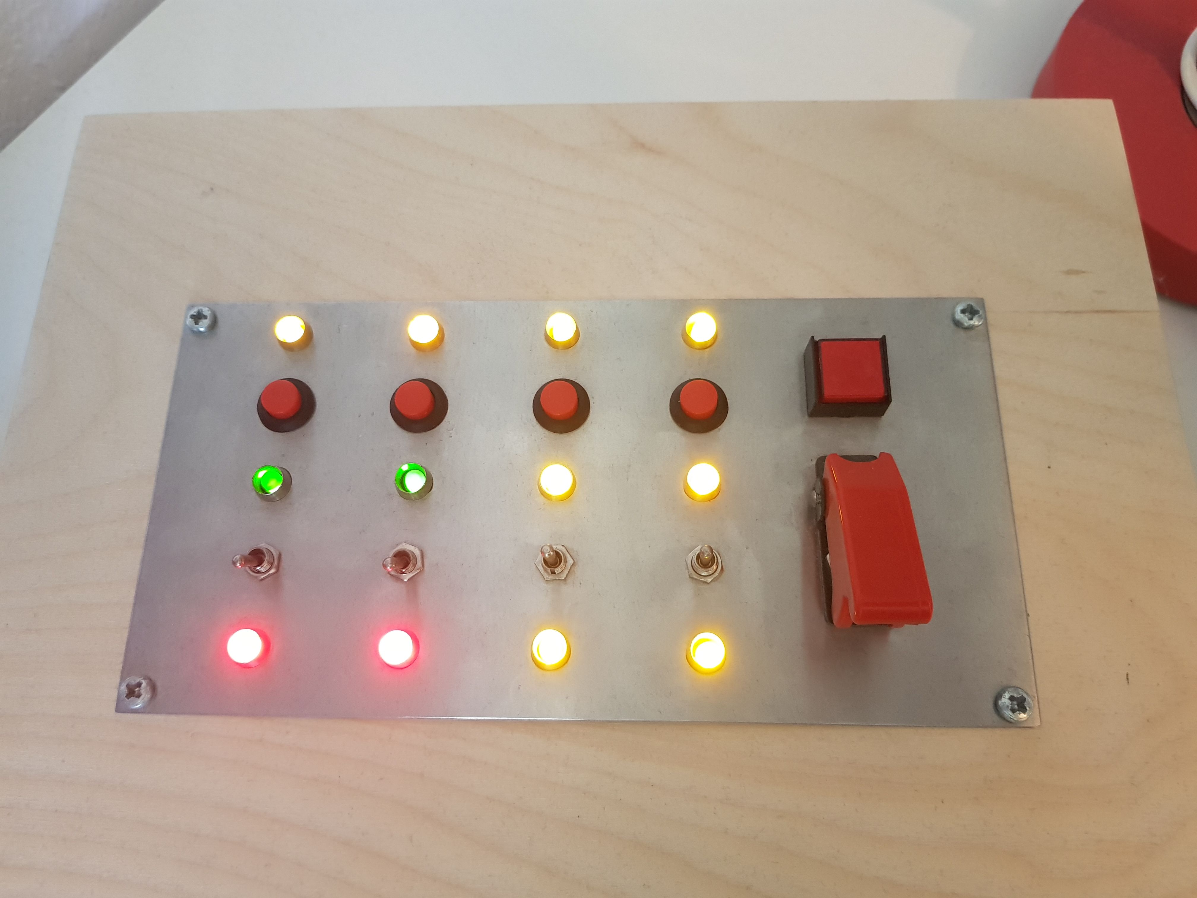 buttons and lit leds on a metal backplate with wooden housing